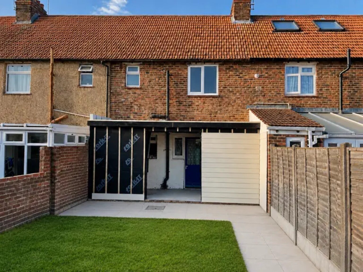 Rear of the property after the external carpentry phase with new covered structure and landscaped garden
