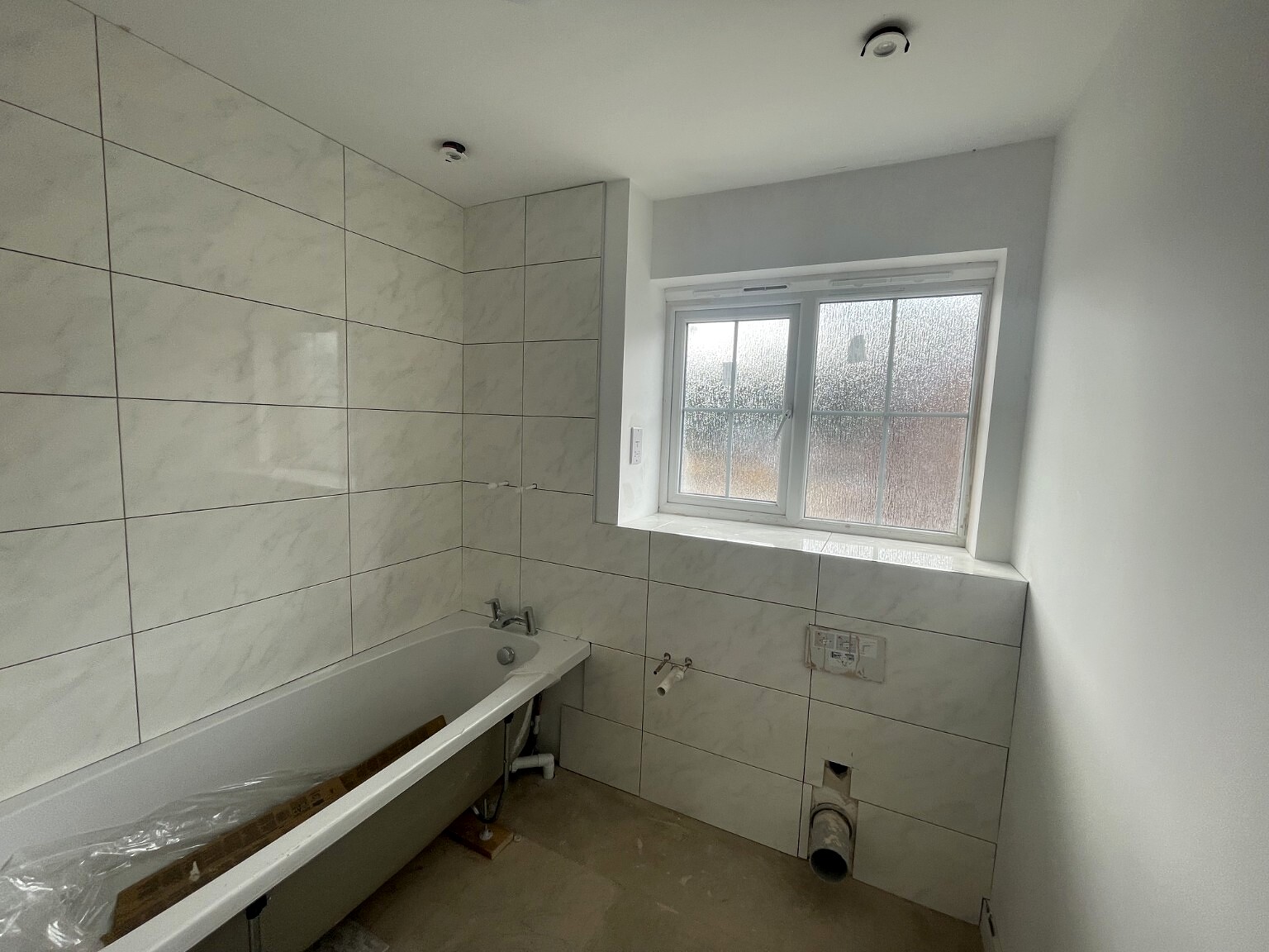 Bathroom fit-out in progress with large-format wall finish