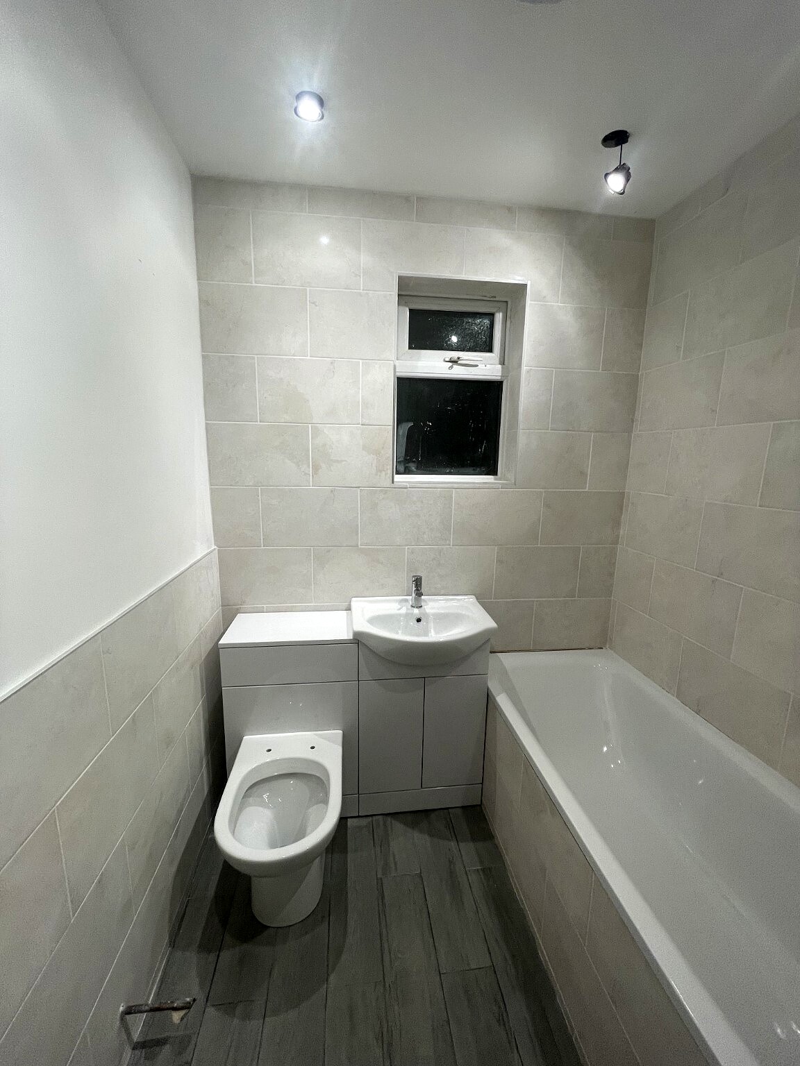 Completed compact bathroom with fitted bath and vanity