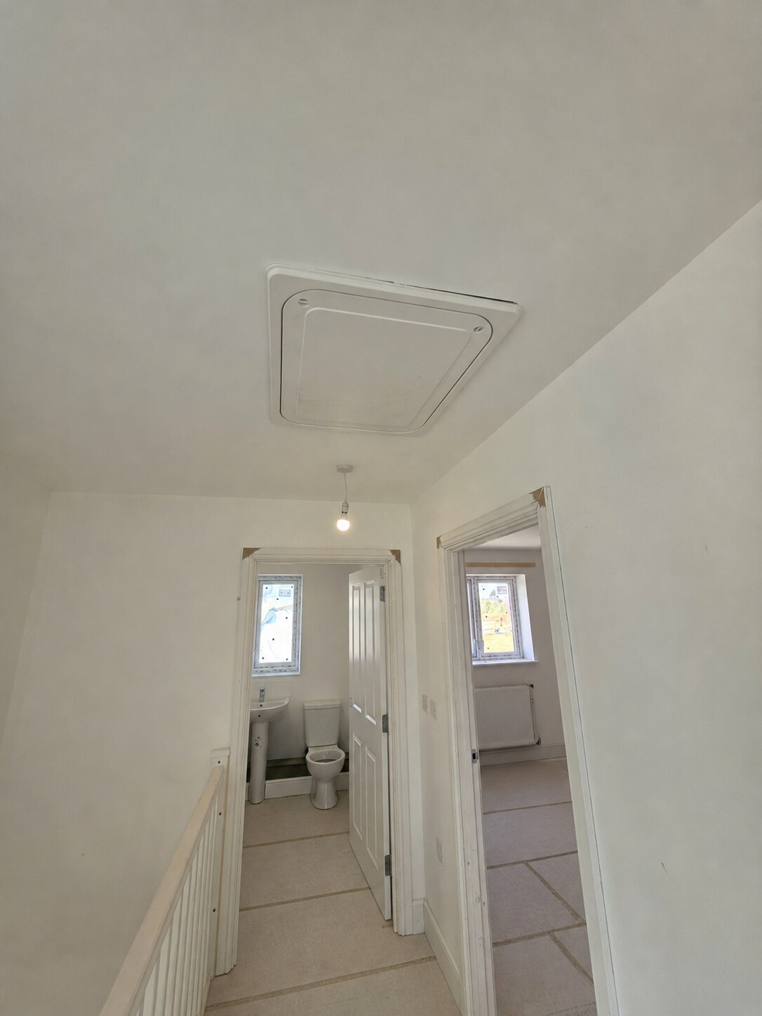 First-floor landing with fitted loft hatch, doors and architraves