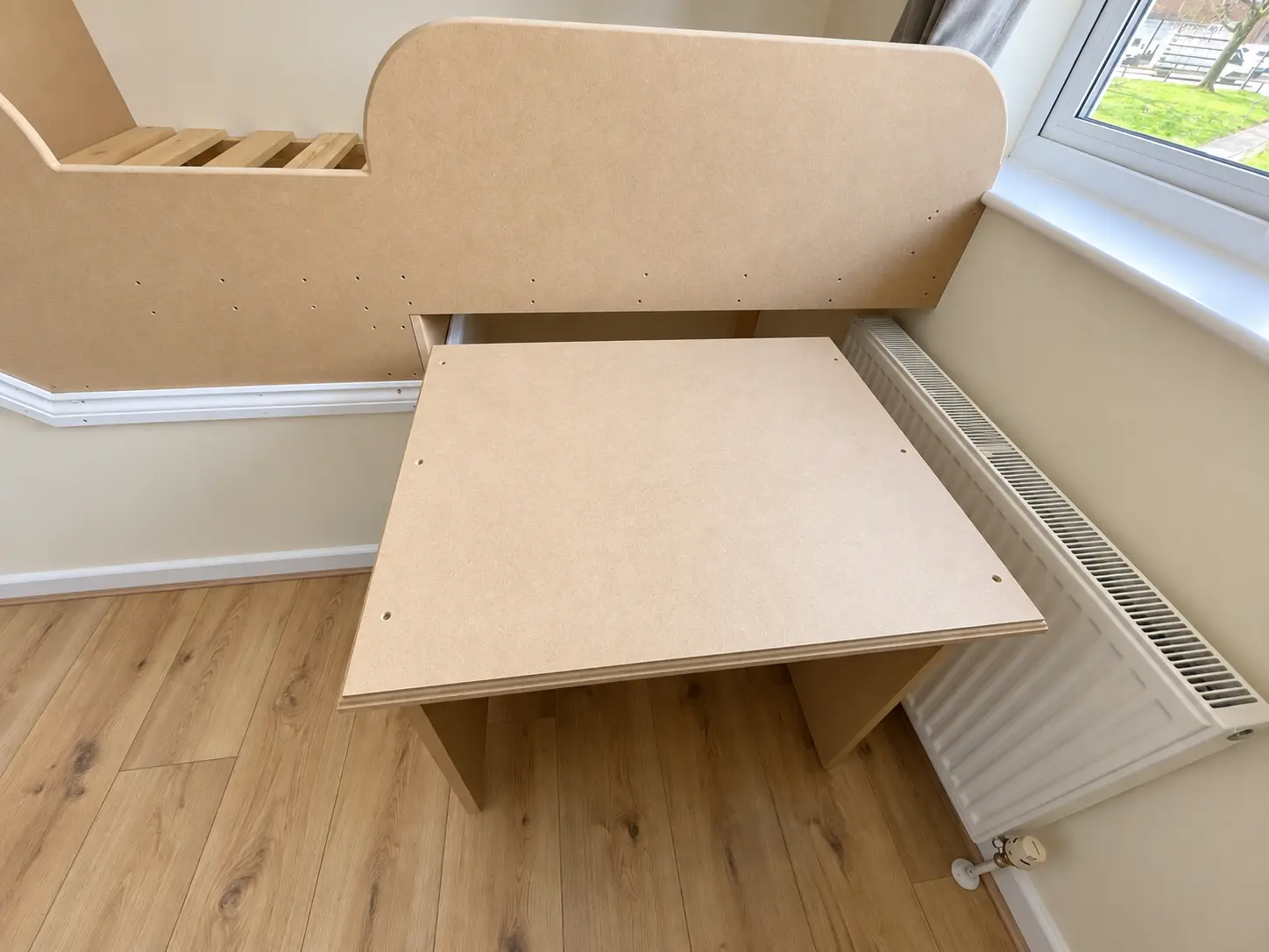 Pull-out desk extended beneath the raised bed