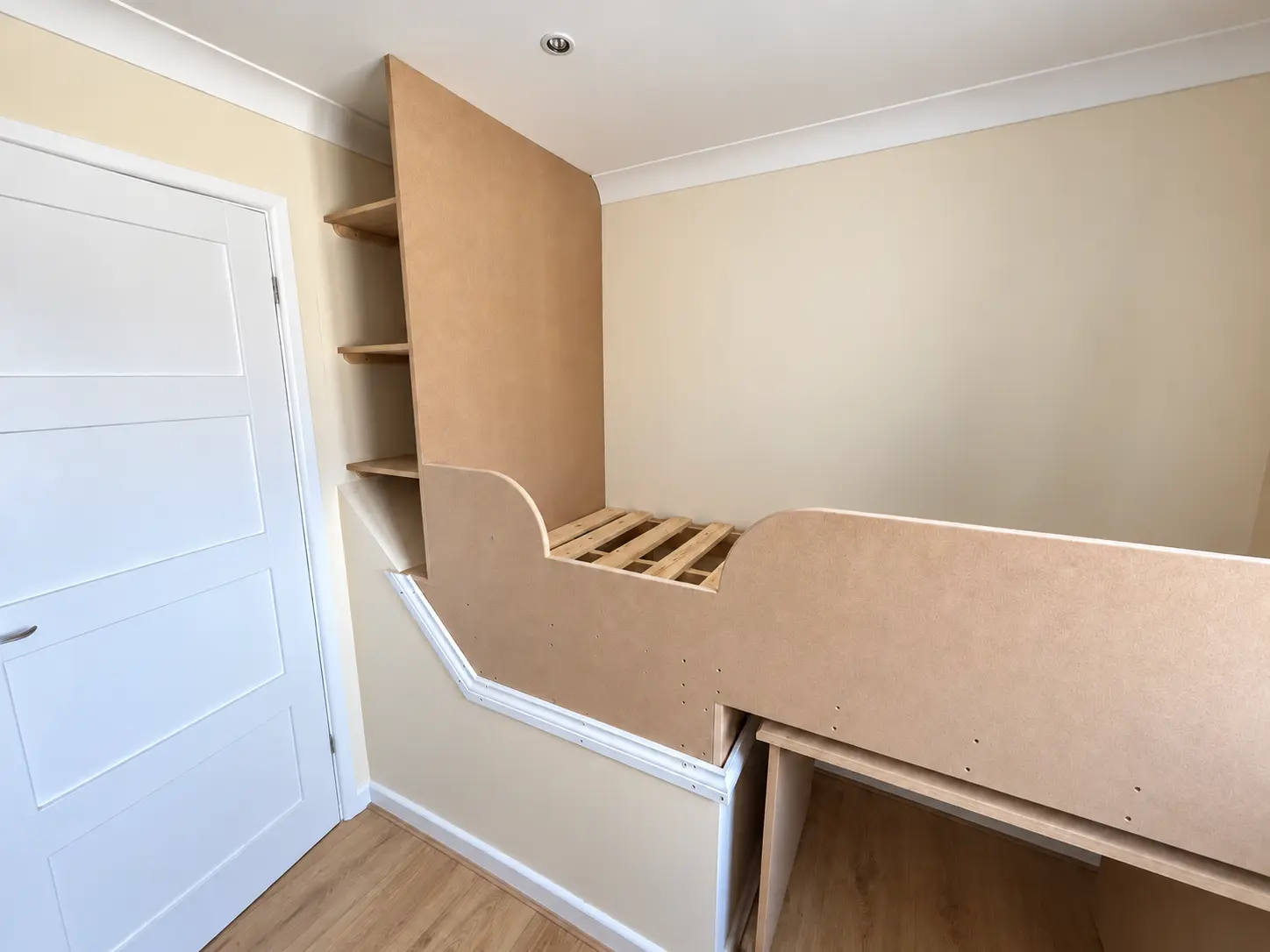 Wide view of the bespoke raised bed, shelving and pull-out desk
