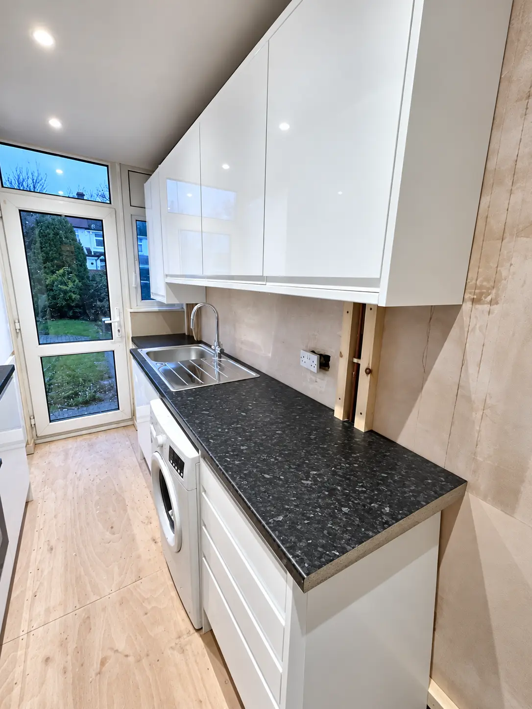 Sink and utility run in the compact white kitchen