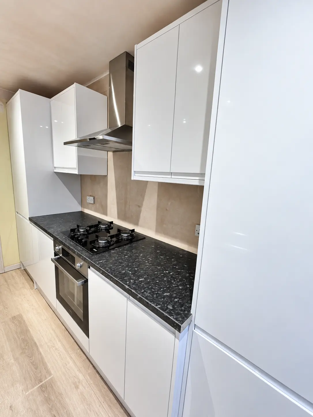 Hob, oven and tall storage within the kitchen cooking run
