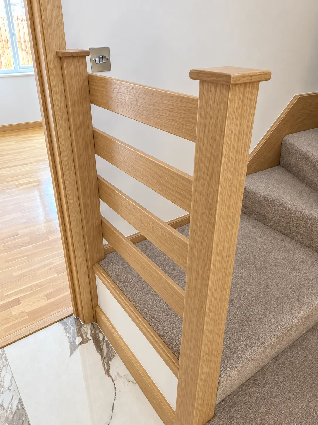 Light-oak staircase refurbishment visual at the lower landing and newel